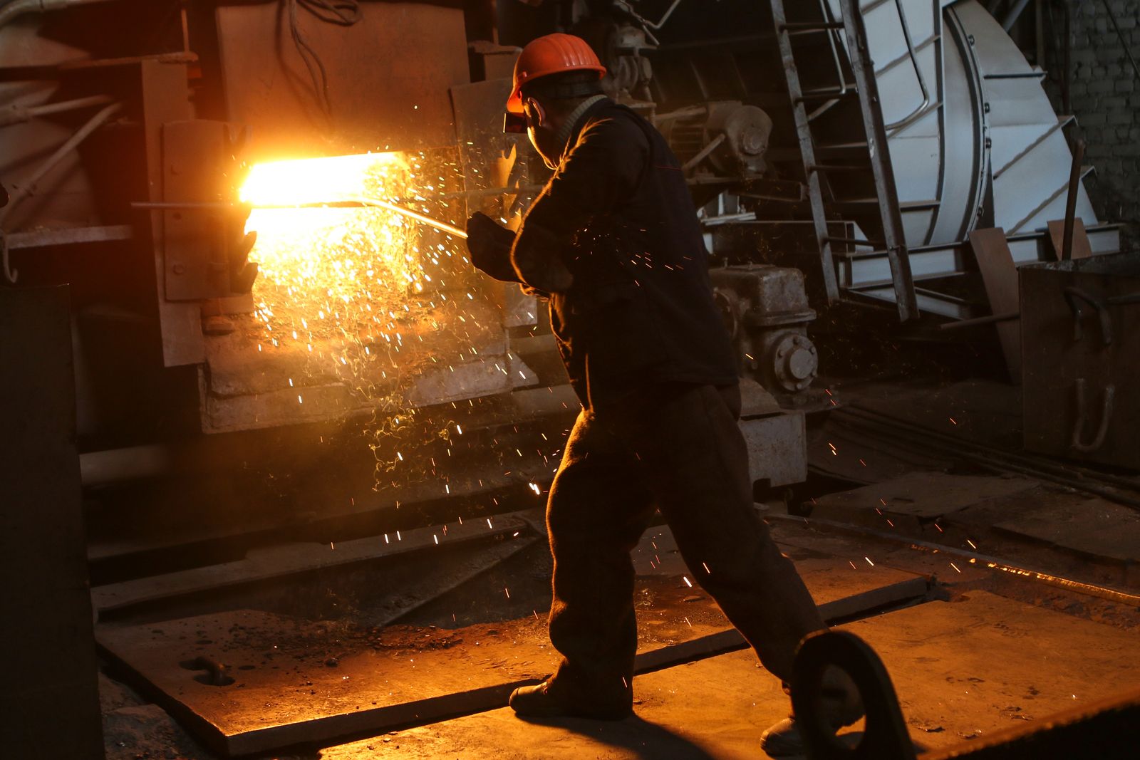 Operator working at a furnace inside a heavy-industry plant