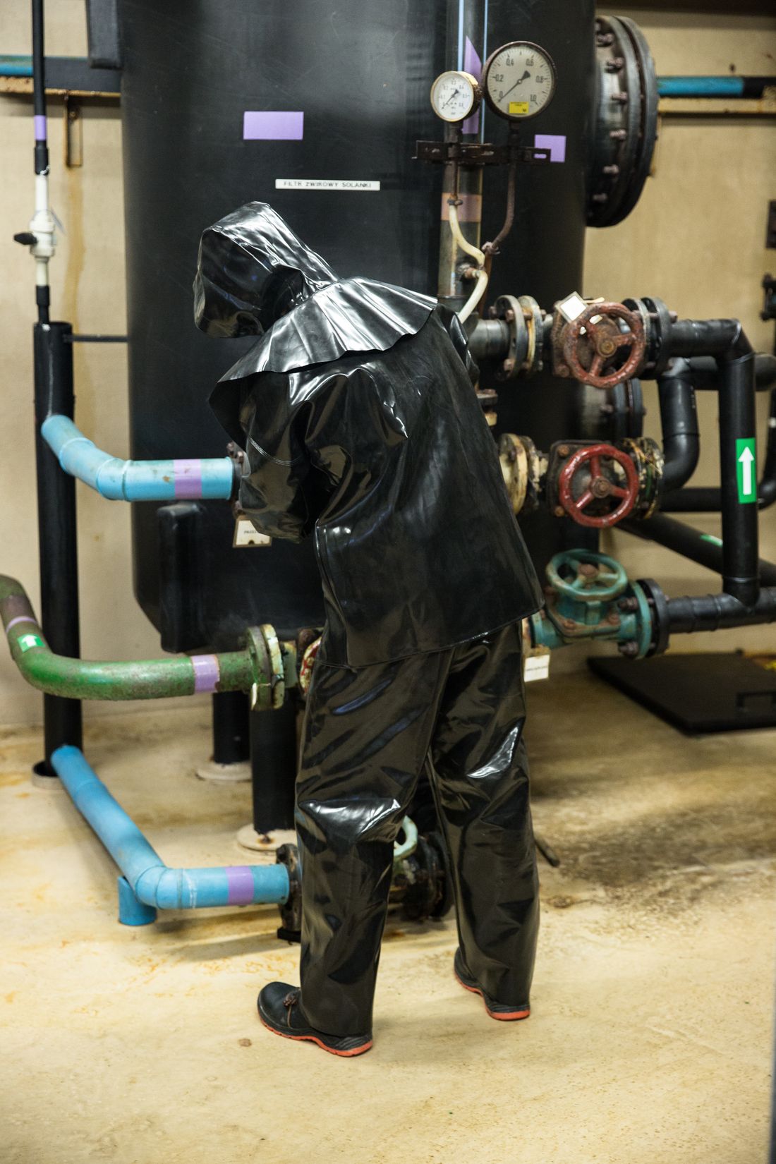 Worker in chemical protective gear at a process unit